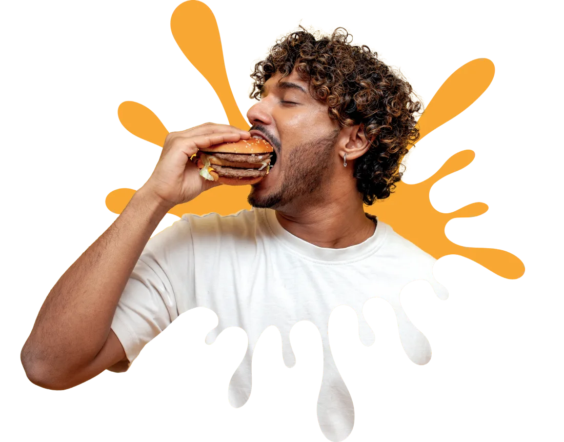 Un homme croque dans un burger, sur fond d’éclaboussure de sauce